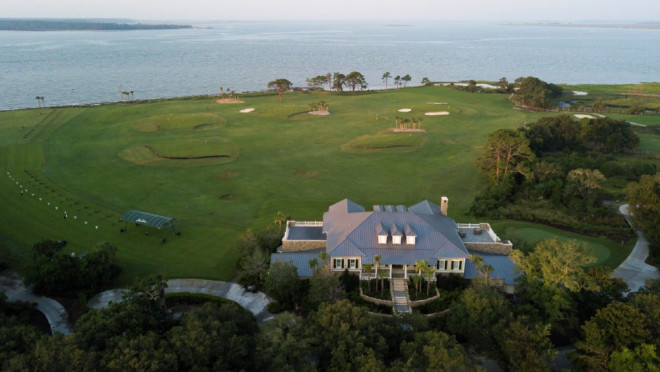 aerial perspective of a large clubhouse set on a golf course near the ocean's edge