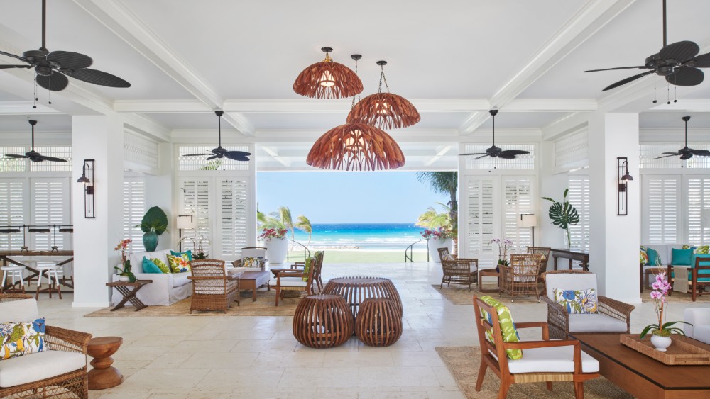 reception area for half moon eclipse resort in jamaica. white open space adorned with natural materials and furnishings while overlooking the water.