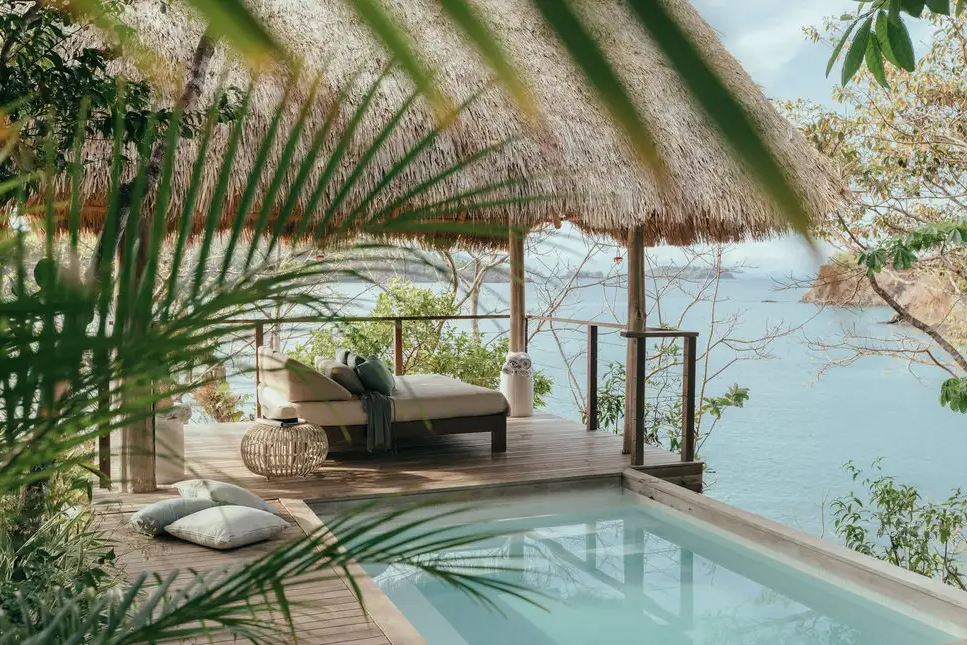 private pool cabana with 180 degree views of the tuqruoise ocean and small, modern sun chaise