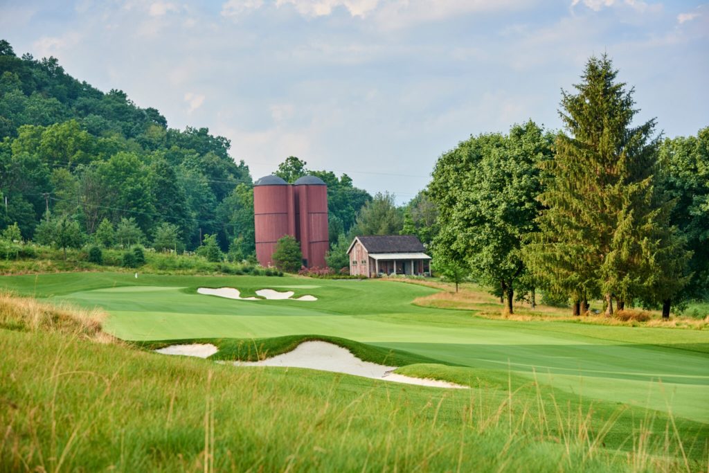 barn and two silos set in a pastoral, golf setting