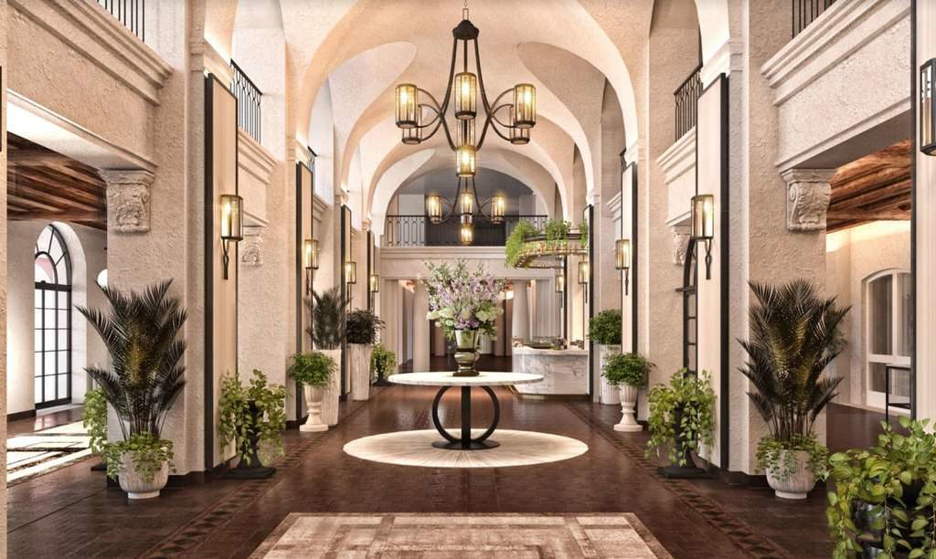 interior rendering of a hotel lobby with spanish revival details, white stucco and a large iron chandelier