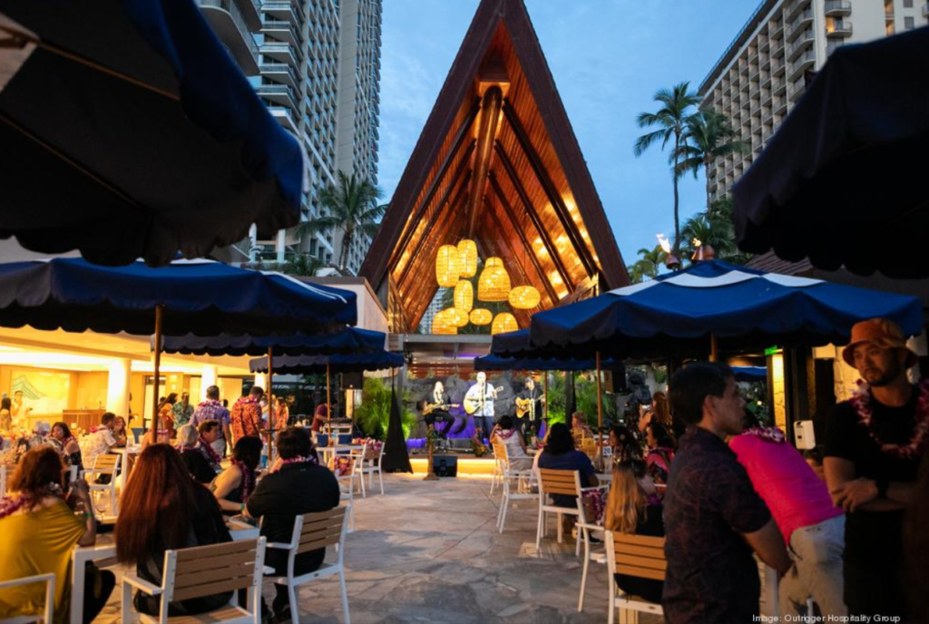 restaurant with people dining outside and a large upside down outrigger boat / band shell
