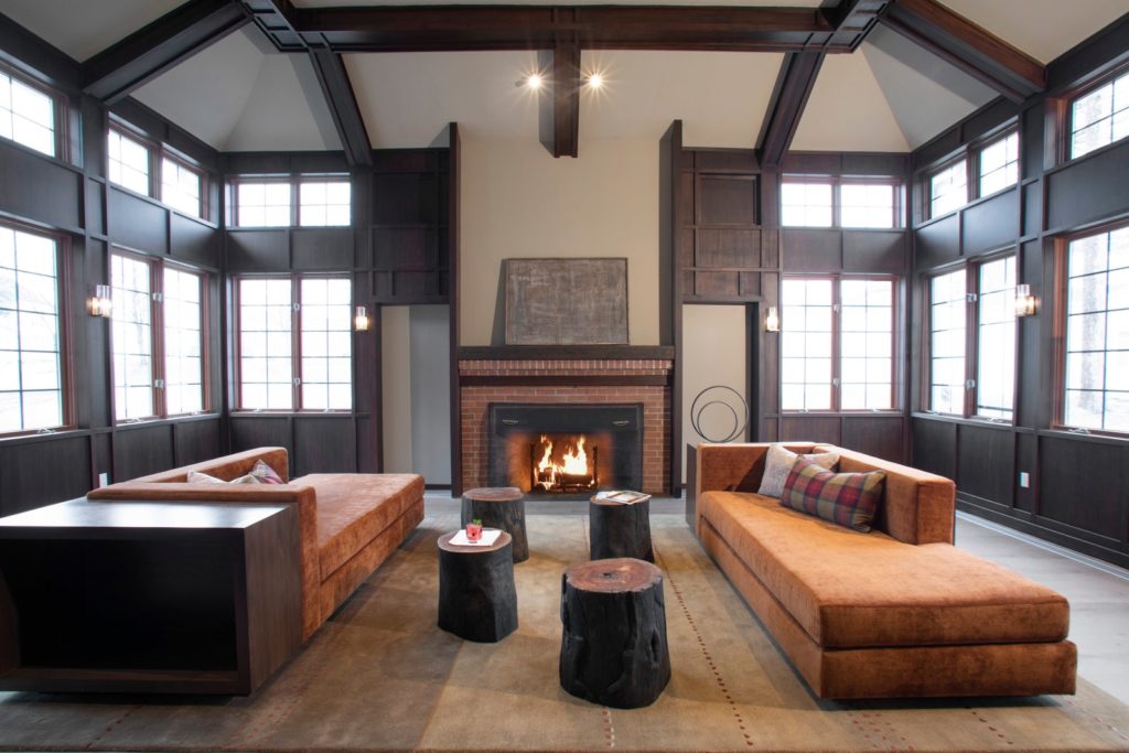 hotel lobby in brown tones with a fireplace and modern sofas with wooden accents throughout