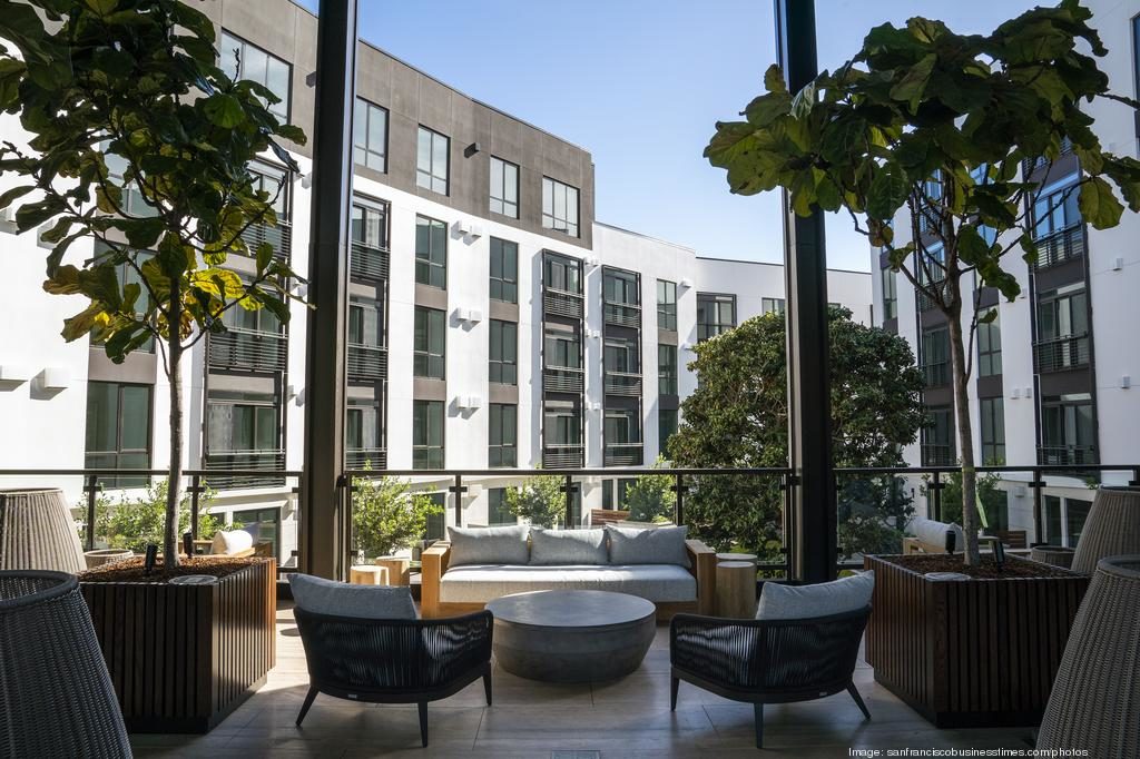 lobby area looking out into a courtyard with greenery and modern architecture surrounding